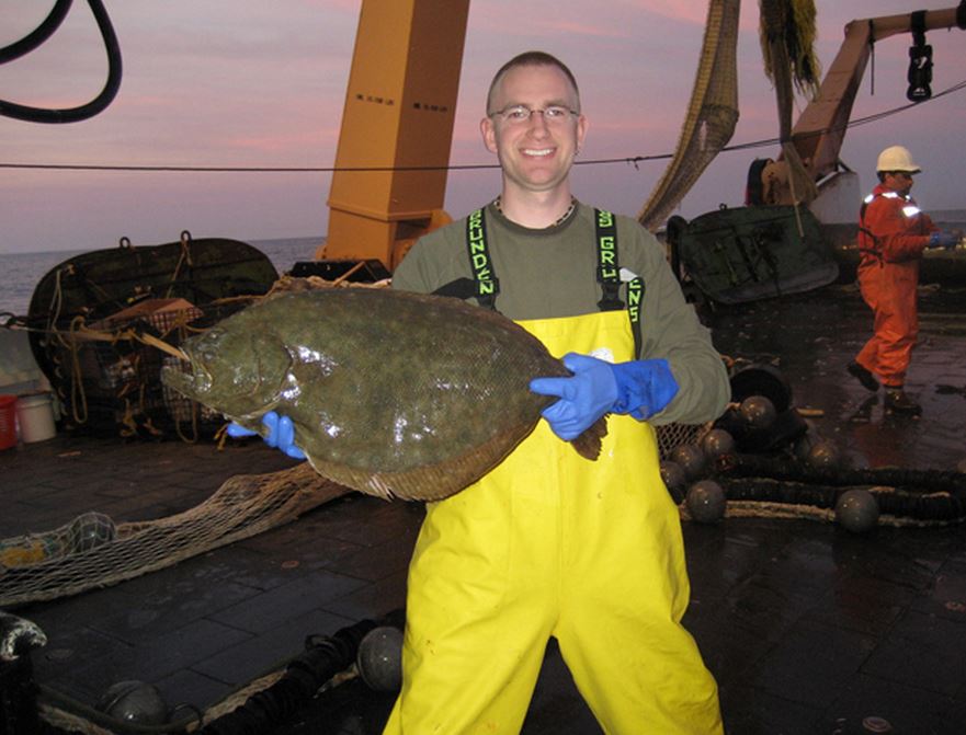 A photo of a man holding an adult summer flounder